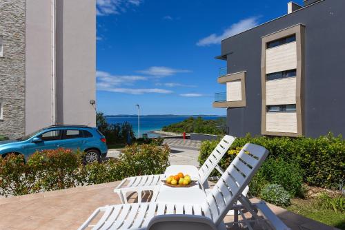 a table and chairs on a patio with a view of the ocean at Sunset Beach Suites in Kožino