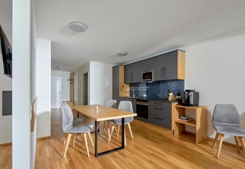a kitchen and dining room with a table and chairs at Zapfig Living Arlberg in Wald am Arlberg