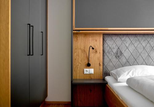 a bedroom with a bed and a tv on a wall at Zapfig Living Arlberg in Wald am Arlberg