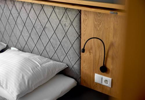 a bedroom with a white pillow and a headboard at Zapfig Living Arlberg in Wald am Arlberg