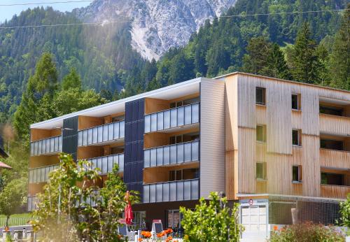 un bâtiment avec une montagne en arrière-plan dans l'établissement Zapfig Living Arlberg, à Wald am Arlberg