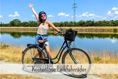 Una donna in bicicletta con la mano in aria di Uhlpartment - Romantisches Apartment im Zentrum a Uelzen