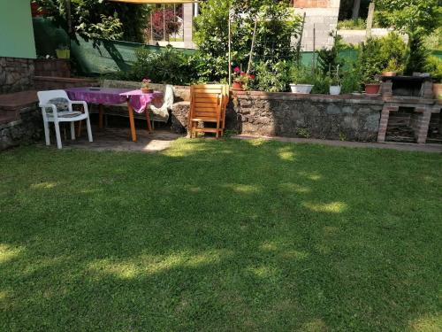 a backyard with a table and chairs and a table and a lawn at SUNSHINE house in Orfű