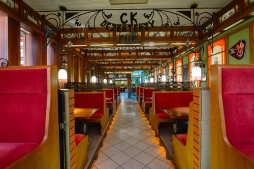 un wagon vide avec des chaises et des tables rouges dans l'établissement Hotel Kosmowski, à Września