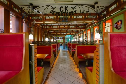 弗熱希尼亞的住宿－Hotel Kosmowski，一辆装有红色椅子和桌子的空火车车厢