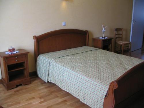 1 Schlafzimmer mit einem Bett sowie 2 Tischen und Stühlen in der Unterkunft Le presbytere in Douzy