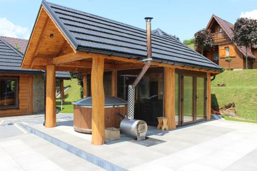a wooden house with a grill in a yard at Jaworina- Apartamenty, Domki i Pokoje in Solina