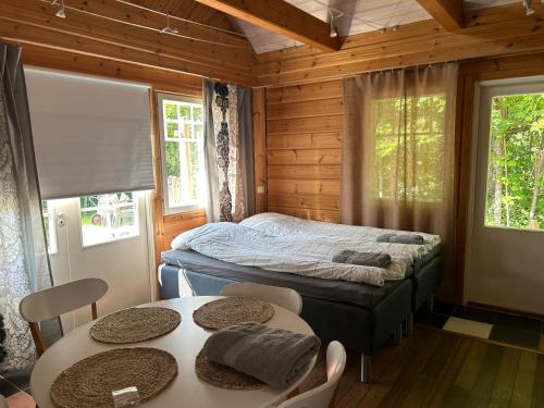 Villa Tourula في يوفاسكولا: غرفة نوم بسرير وطاولتين وكراسي