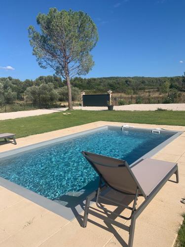 une chaise assise à côté d'une piscine dans l'établissement Provencelia, à Pernes-les-Fontaines