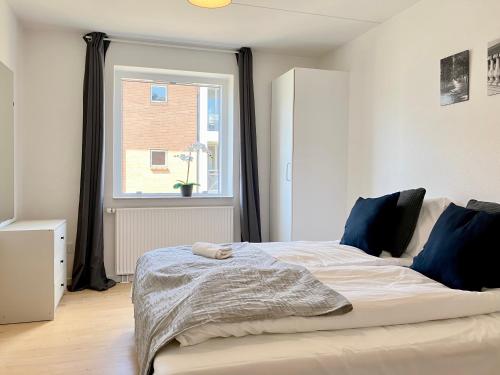 1 dormitorio con 1 cama grande y ventana en Newly Renovated Two Bedroom Apartment In City Center Of Herning, en Herning