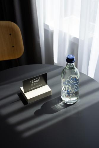 a bottle of water and a book on a table at Fred Hotel Zürich Hauptbahnhof in Zürich