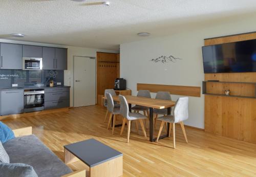 a kitchen and living room with a table and chairs at Zapfig Living Arlberg in Wald am Arlberg