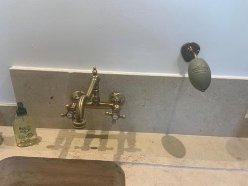 un robinet en laiton avec une bille sur le mur dans l'établissement Provencelia, à Pernes-les-Fontaines