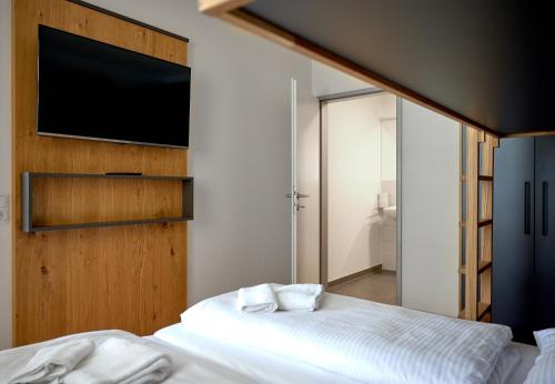 a bedroom with two beds and a flat screen tv at Zapfig Living Arlberg in Wald am Arlberg