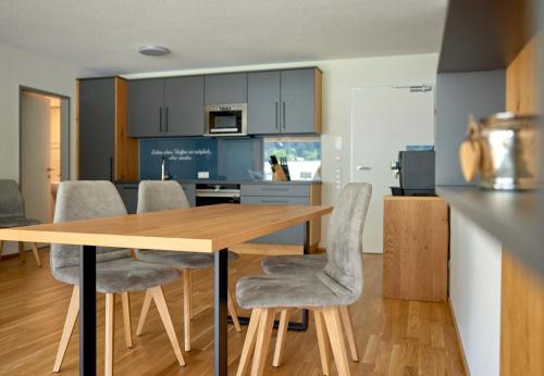 a kitchen and dining room with a wooden table and chairs at Zapfig Living Arlberg in Wald am Arlberg