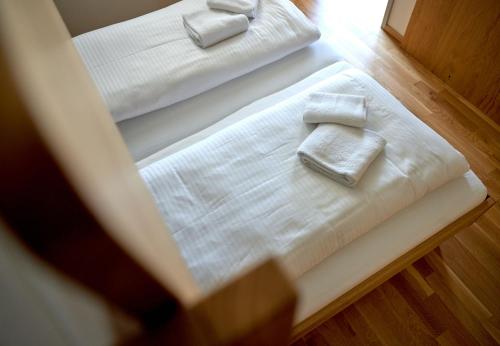 two white beds with towels on top of them at Zapfig Living Arlberg in Wald am Arlberg