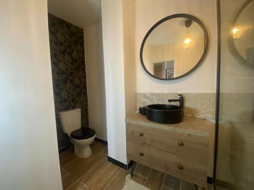 une salle de bain avec un lavabo et un miroir et des toilettes dans l'établissement White Wood, à Narbonne
