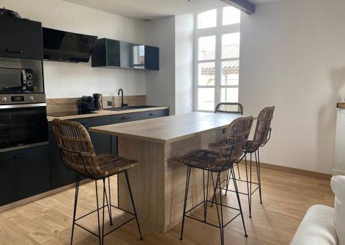 une cuisine avec un îlot et des tabourets de bar dans l'établissement White Wood, à Narbonne