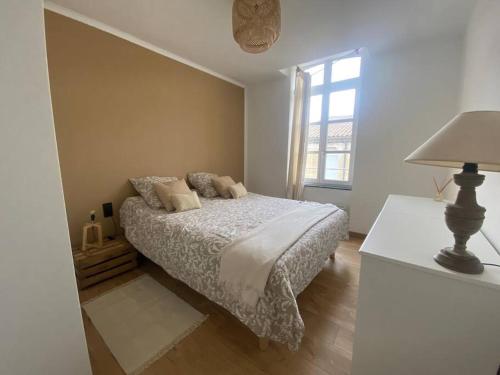 une chambre avec un lit, une lampe et une fenêtre dans l'établissement White Wood, à Narbonne