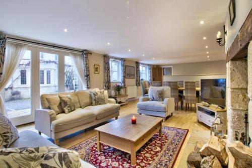 uma sala de estar com um sofá e uma mesa em Olive Cottage by Group Retreats em Bampton