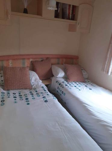 Tempat tidur dalam kamar di Central Located Caravan Near the Beach