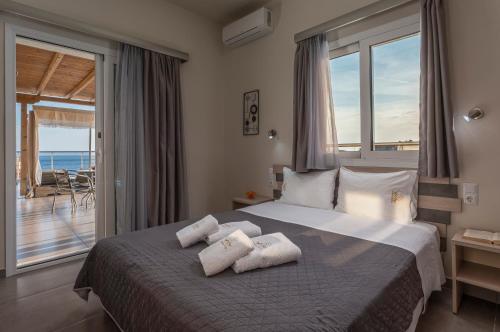 a bedroom with a bed with a view of the ocean at Sunshine Apartments in Neos Marmaras