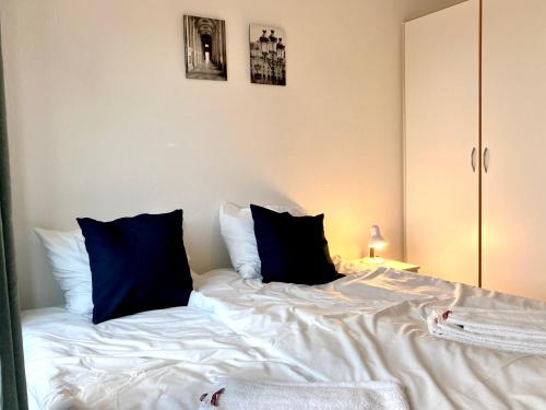 a white bed with blue pillows on top of it at Cosy 1-bedroom Apartment In Herning in Herning