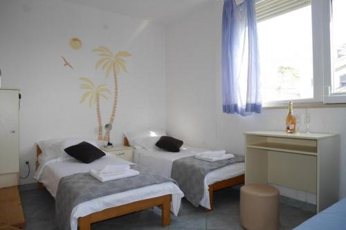 Cette chambre comprend 2 lits et une fenêtre. dans l'établissement Apartment in Dugi Rat with sea view, balcony, air conditioning WiFi 5132-1, à Dugi Rat