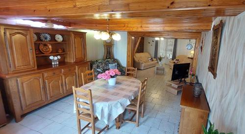 a dining room with a table and a kitchen at Chez marcelle in Éteignières