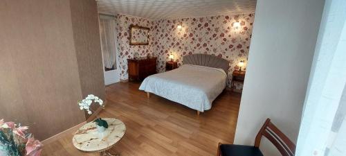 a bedroom with a bed and floral wallpaper at Chez marcelle in Éteignières