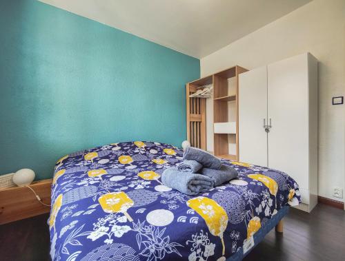 - une chambre avec un lit doté d'une couette bleue et jaune dans l'établissement Maison chaleureuse et spacieuse, à Lacanau