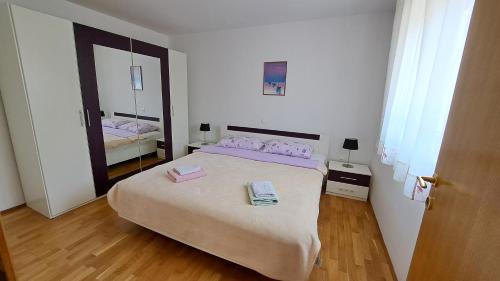 a bedroom with a large bed and a mirror at Cozy Apartments Baška in Baška