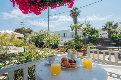 a table with a plate of food and orange juice at Nostos Sifnos in Apollonia