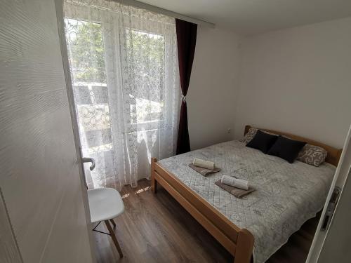a small bedroom with a bed and a window at Podinario in Soko Banja