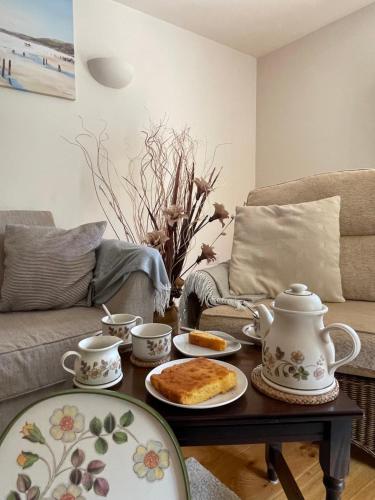 uma sala de estar com um conjunto de chá numa mesa de centro em Creedy Meadow Barn em Crediton