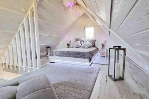 a white bedroom with a bed and a staircase at O bulles d'Agon Chalet Spa privé Plage in Agon Coutainville