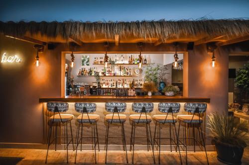a bar with a row of stools at Vice Hotel in Laganas