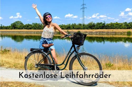 a woman riding a bike with her hand in the air at Uhlpartment - im Herzen von Uelzen in Uelzen