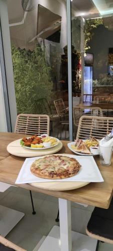 a wooden table with two plates of pizza on it at Kiperi Exclusive in Parga