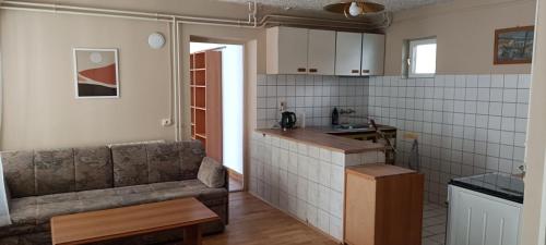 cocina y sala de estar con sofá y mesa en Holiday Apartment, en Badacsonytördemic