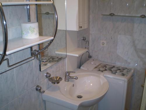 La salle de bains est pourvue d'un lavabo, de toilettes et d'un miroir. dans l'établissement Apartment in Novi Vinodolski with air conditioning, WiFi, washing machine 3541-4, à Novi Vinodolski