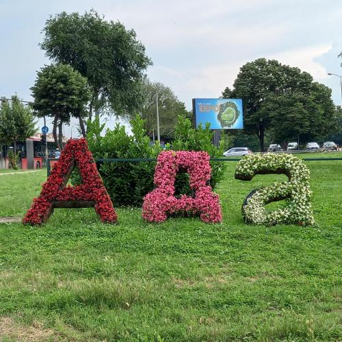 a sign for a park with flowers in the grass at RIVIJERA LAKES Ada Studio in Belgrade
