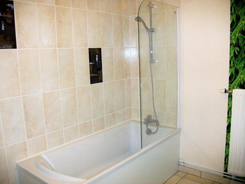 a bathroom with a bath tub with a shower at Les rosieres 