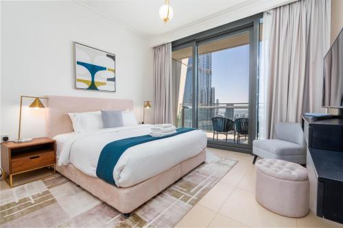 a bedroom with a large bed and a balcony at Vacay Lettings - High floor Burj Khalifa & Fountain view 3 bed in Dubai