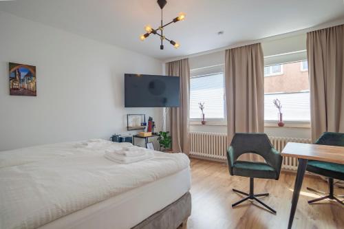 Dormitorio con cama, escritorio y TV en City Apartment in berühmter Lage, en Hildesheim