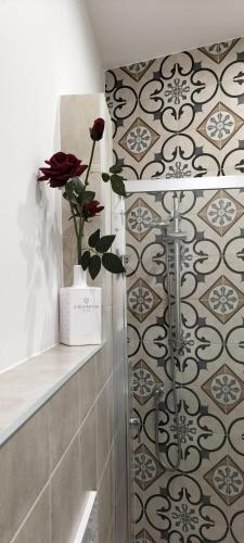 ein Badezimmer mit einer Dusche mit einer Blume in einer Vase in der Unterkunft Le Scale di Pietra in Conversano