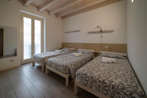 een kamer met 2 bedden en een raam bij #Franciacortalovers in Rodengo Saiano