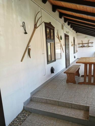 a patio with a wooden table and a bench at Körűnéző Vendégház in Nagykörů