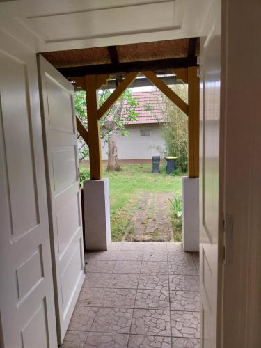 an open door leading to a yard with a house at Körűnéző Vendégház in Nagykörů