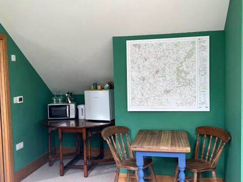 a kitchen with a table and a refrigerator and a microwave at 2 Guests Studio - Free Parking - Stunning Views in Bruton